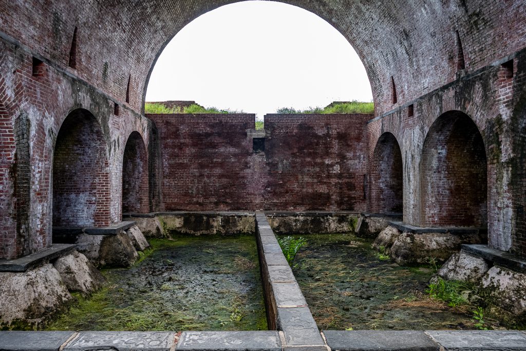 Stone arch opening onto a partially ruined courtyard.