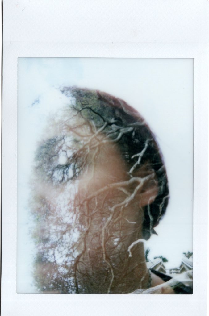 Experimental instant portrait with a face partially obscured by translucent texture.