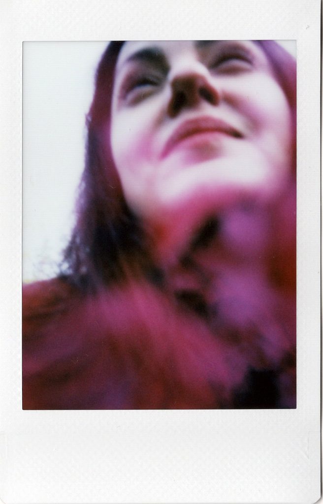 Soft-focus portrait in pink and violet tones.